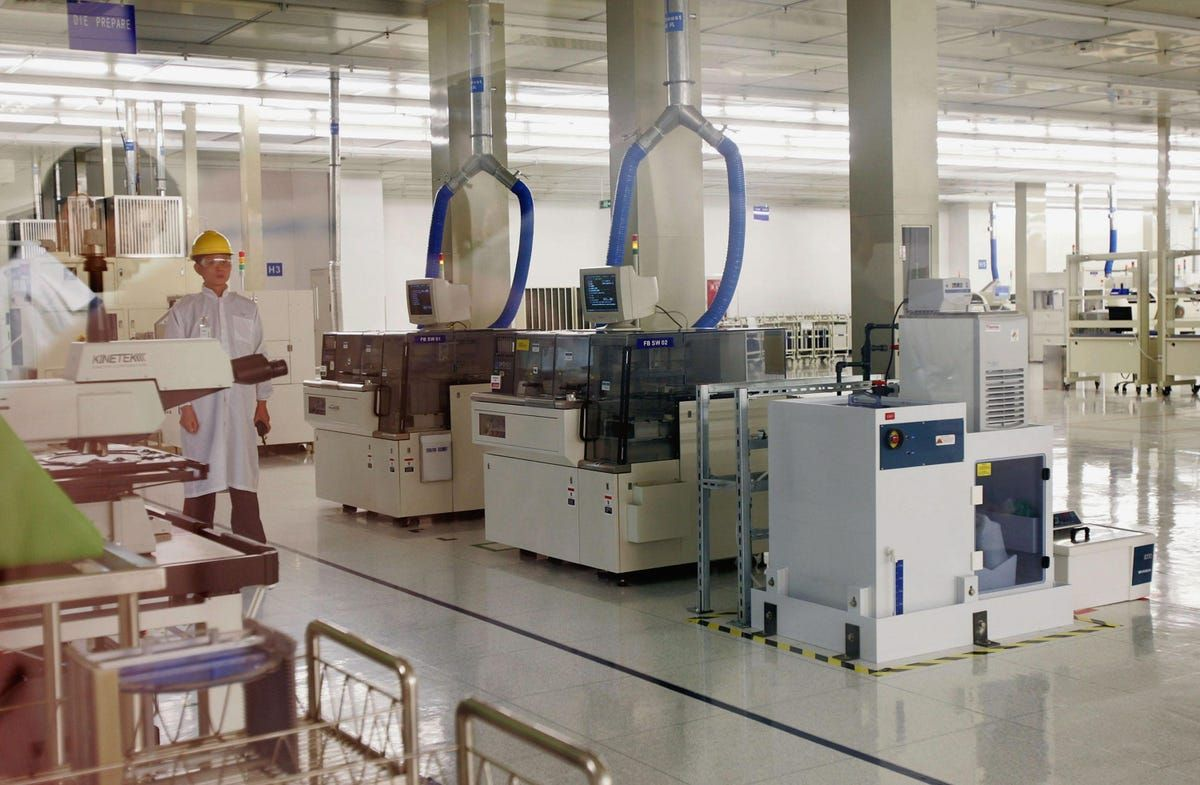 Interior of a next-generation semiconductor fabrication plant with automated manufacturing equipment and cleanroom robotics