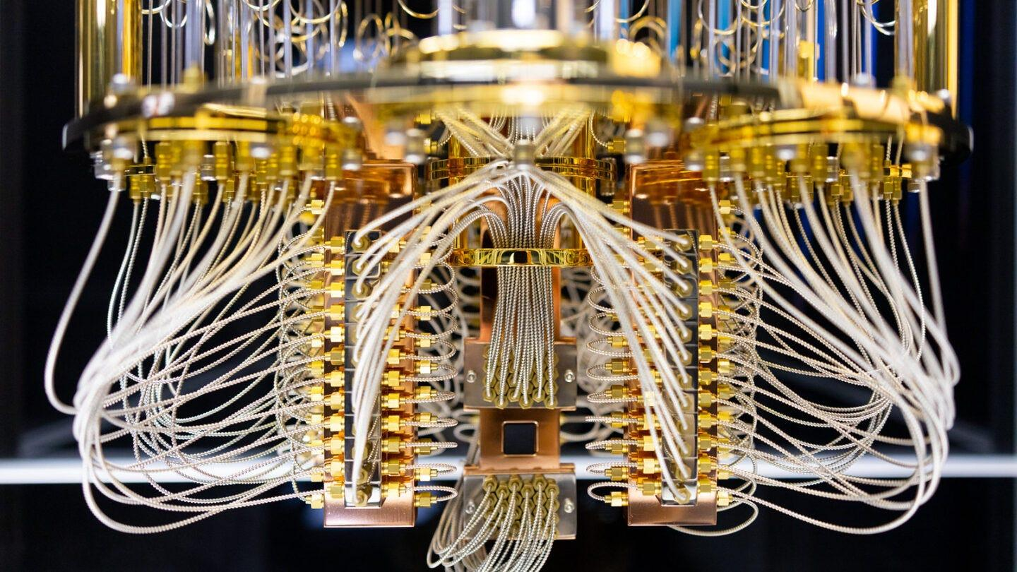 Engineer inspecting a quantum-inspired processor chip on a circuit board